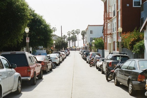 imagem de uma rua com carros estacionados dos dois lados
